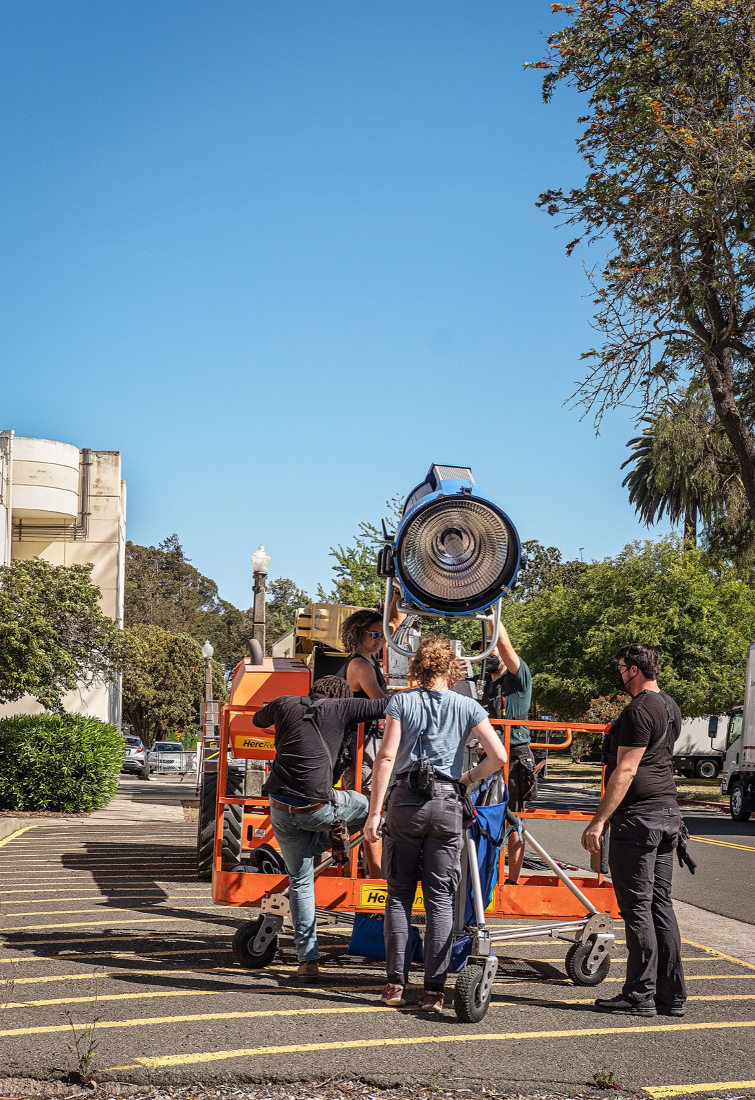 Reference image of a crew positioning a large cinema light