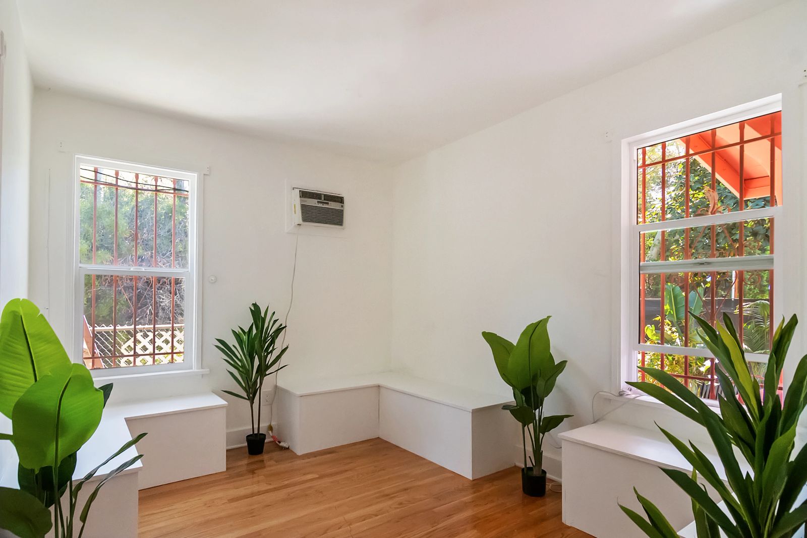 Bright Silver Lake interior with white walls, wood floors, windows and plants
